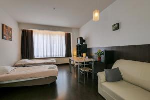 Habitación con 2 camas, sofá y mesa. en Budget Flats Antwerp, en Amberes
