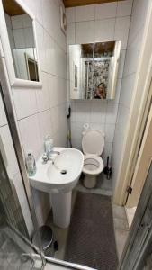 a bathroom with a sink and a toilet and a mirror at Palaz 5 - 3 bedroom Apartment in Edmonton