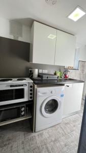 a kitchen with a washing machine and a microwave at Palaz 5 - 3 bedroom Apartment in Edmonton