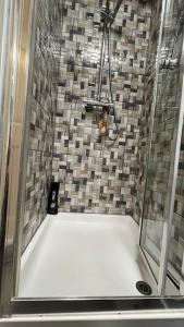 a bathroom with a shower with a shower Bed M Hbestosbestosbestosbestosbestos at Palaz 5 - 3 bedroom Apartment in Edmonton