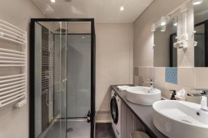 uma casa de banho com uma cabina de duche em vidro e um lavatório. em Le Phare de la Fenêtre em Cancale
