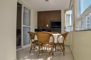 a dining room with a table and chairs at Ótima Localização!!! Apartamento De Frente No Centro De Capão Da Canoa in Capão da Canoa +65 photos