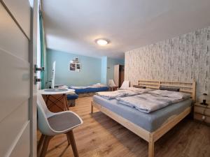ein Schlafzimmer mit einem Bett, einem Tisch und einem Stuhl in der Unterkunft Willa Słoneczko in Duszniki-Zdrój
