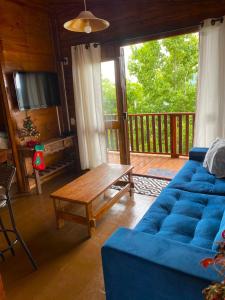 a living room with a blue couch and a wooden table at Cabana Alto do Monte in Gramado