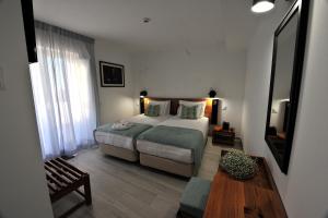 - une chambre avec un grand lit et du parquet dans l'établissement Hotel Búzio, à Sines
