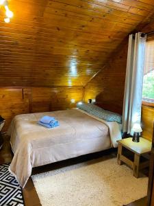 a bedroom with a bed in a wooden cabin at Cabana Alto do Monte in Gramado