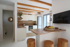 a kitchen with a counter with a bowl of fruit on it at The Nine Graces - Kastraki Villas with Private Swimming Pool in Kastraki Naxou