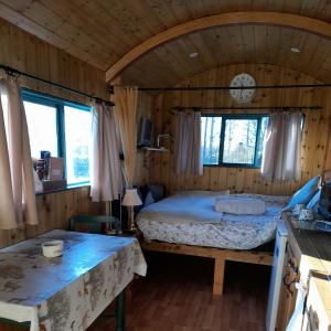 ein Schlafzimmer mit einem Bett und einer Uhr an der Wand in der Unterkunft Lower Haven Shepherds Hut in Bath