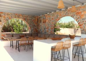a room with a brick wall and a table and chairs at The Nine Graces - Kastraki Villas with Private Swimming Pool in Kastraki