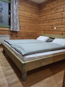 a bed in a room with a wooden wall at Apartment Jeršin in Rateče