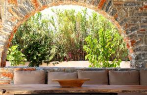 a brick wall with a table and some plants at The Nine Graces - Kastraki Villas with Private Swimming Pool in Kastraki