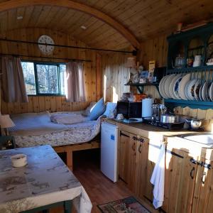 uma cozinha com uma cama num chalé de madeira em Lower Haven Shepherds Hut em Bath