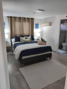 1 Schlafzimmer mit einem großen Bett und einem Badezimmer in der Unterkunft Palm Beach Paradise Vacation Rental in Palm-Eagle Beach