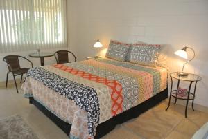 1 dormitorio con 1 cama con 2 mesas y 2 lámparas en Borrego Springs Motel en Borrego Springs