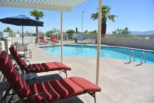 - une piscine avec des chaises et un parasol à côté de la piscine dans l'établissement Borrego Springs Motel, à Borrego Springs