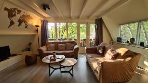 un salon avec un canapé et une table dans l'établissement The Deer Lodge Durbuy, à Durbuy