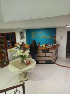 a woman standing at the counter of a pizza restaurant at Hotel Plaza Real Ocaña in Ocaña