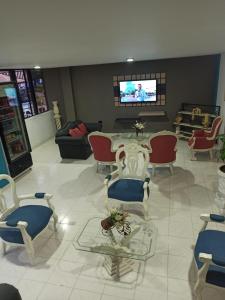 un soggiorno con sedie, tavolo e TV di Hotel Plaza Real Ocaña a Ocaña
