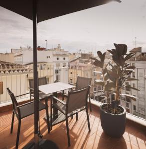 a table and chairs on a balcony with a plant at Anderson City Flats in Valencia