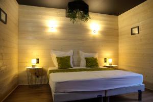 1 dormitorio con 1 cama en una pared de madera en Gîte des Amis, 