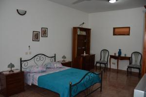 Residencial Chez Flor في بورتو نوفو: غرفة نوم بسرير وبطانية زرقاء وكرسيين