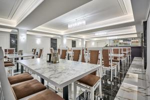 a dining room with a marble table and chairs at Olimp Hotel in Bukovel