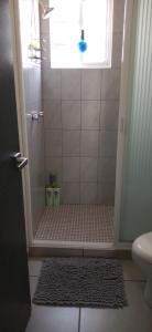 a bathroom with a shower with a window and a rug at Casa Aqua, con alberca y club de playa in Barra Vieja
