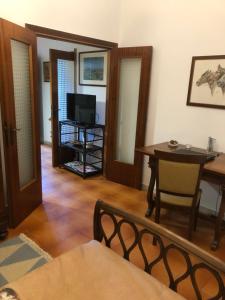un salon avec une table et une télévision dans l'établissement La Poderina, à Monteriggioni