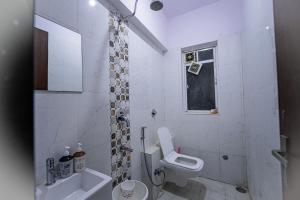 a white bathroom with a toilet and a sink at Staeg Night Sky View 2BHK - 1605 in Indore