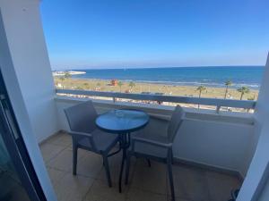 d'un balcon avec une table et des chaises et une vue sur la plage. dans l'établissement Alex Beach Apartment 33, à Larnaka