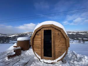 un sauna en bois avec de la neige au sol dans l'établissement Klimatyczny drewniany domek w górach, à Lachowice