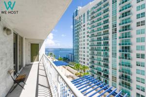 einen Balkon mit blauen Stühlen und einem Gebäude in der Unterkunft We Host - Condo Top Amenities City- Bay View in Miami