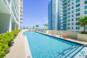 ein Schwimmbad in der Mitte eines Gebäudes mit hohen Gebäuden in der Unterkunft We Host - Condo Top Amenities City- Bay View in Miami