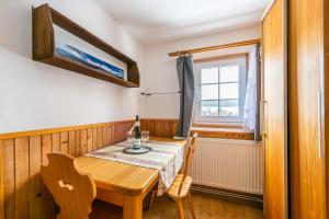 une salle à manger avec une table en bois et une fenêtre dans l'établissement Penzion Černý vlk, à Kvilda