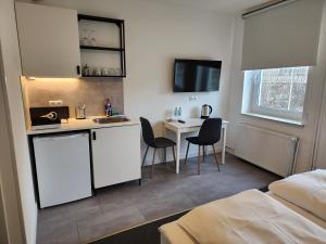 a room with a kitchen with a sink and a desk at Davin City Aparments - Self-Check-In in Hamburg