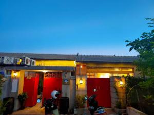 een huis met rode deuren en twee scooters buiten geparkeerd bij Old Mamaboy Marines Hostel獨立包棟三間雙人雅房 in Kaohsiung