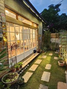 einen Garten mit Topfpflanzen vor einem Haus in der Unterkunft Old Mamaboy Marines Hostel獨立包棟三間雙人雅房 in Kaohsiung