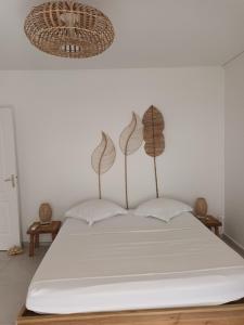 a bedroom with a white bed with two pillows at VILLA ÉLISHA in Saint-Louis