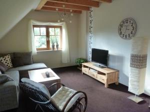 a living room with a couch and a clock on the wall at FeWo La Casa - Ferien im Münsterland in Ahaus