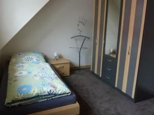 a small bedroom with a bed and a dresser at FeWo La Casa - Ferien im Münsterland in Ahaus