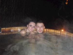 a man and woman in a swimming pool at night at Liptovská Drevenica in Liptovský Mikuláš