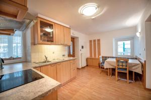 a kitchen with a table and a dining room at Central Apartments Cristlpek in Ortisei