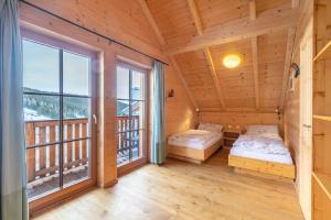 2 Betten in einem Zimmer mit einem großen Fenster in der Unterkunft Veselý Svišť Chalet Lachtal in Lachtal