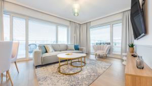 een woonkamer met een bank en een tafel bij Apartament Lux Tukan B004, Polanki Aqua - Holiday City in Kołobrzeg