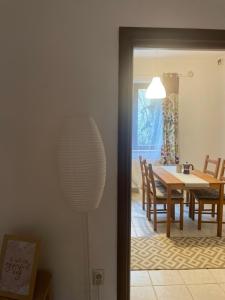 a dining room with a table and chairs and a lamp at BONI Apartman in Miskolctapolca