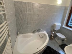 a bathroom with a white tub and a toilet at BONI Apartman in Miskolctapolca