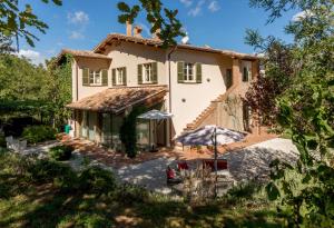 una vista exterior de una casa con sombrilla en Altra Meta b&b, en Gubbio