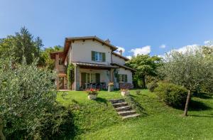 una casa bianca con un cortile alberato di Altra Meta b&b a Gubbio