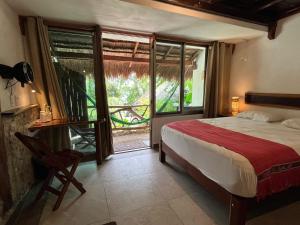 a bedroom with a bed and a view of a yard at Casa Lamat in Bacalar +59 photos