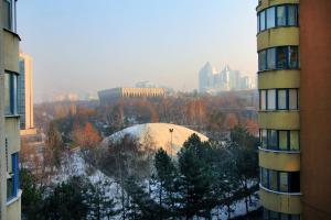 Una vista de una ciudad con un edificio y nieve. en Perfect spacious apartment 365, en Almaty